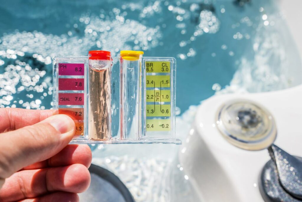 A hand holds up a pool water testing gauge 

