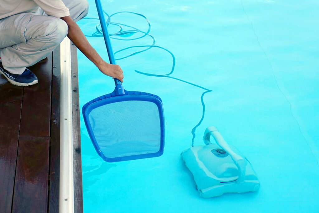Hotel staff worker cleaning the pool 