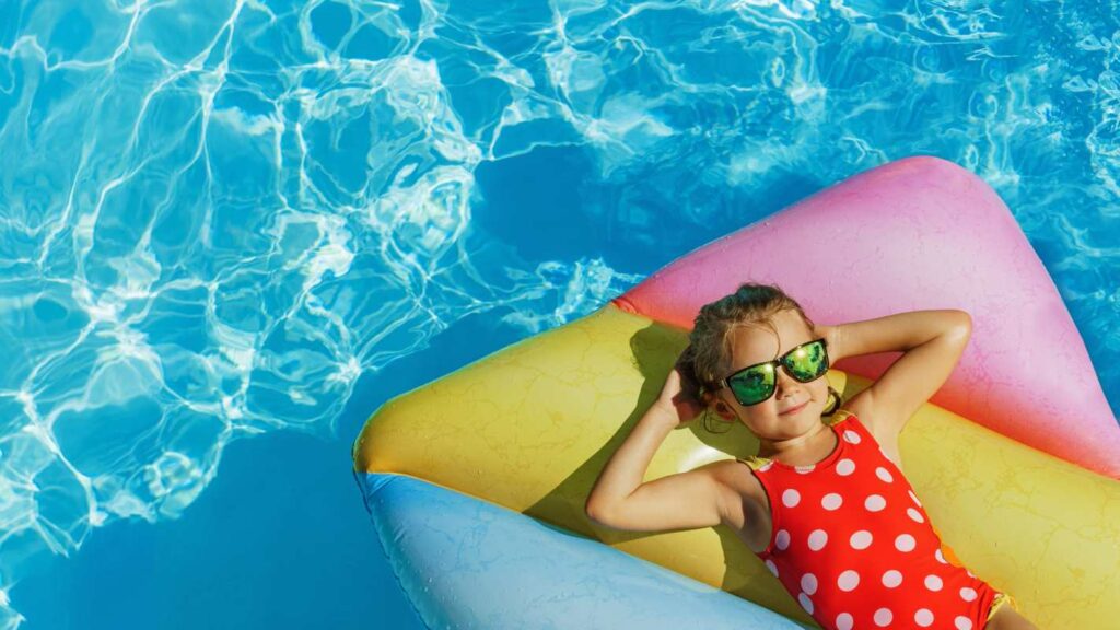 Young girl relaxing on a floaty in a pool 