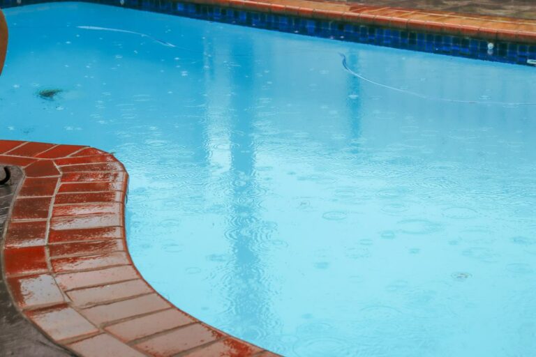 A view of a swimming pool during a rainstorm.