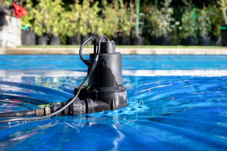 Automatic pool cover pump on top of blue wet pool cover